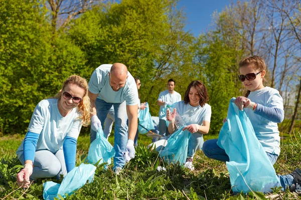 Volontari con sacchi della spazzatura pulizia area del parco — Foto Stock