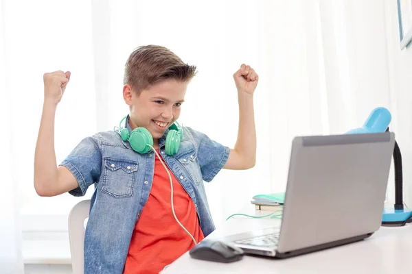 Jongen met hoofdtelefoon voor het afspelen van video game op laptop — Stockfoto