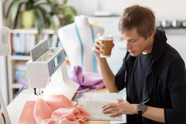 Diseñador de moda con café y libro en el estudio —  Fotos de Stock