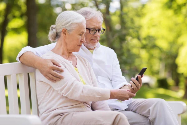 Szczęśliwa para starszy z smartphone przy parku — Zdjęcie stockowe