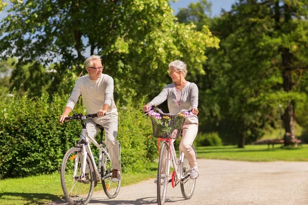 Feliz casal sênior andar de bicicleta no parque de verão — Fotografia de Stock