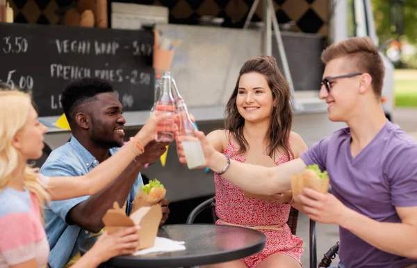 Amis clinking boissons et manger au camion de nourriture — Photo