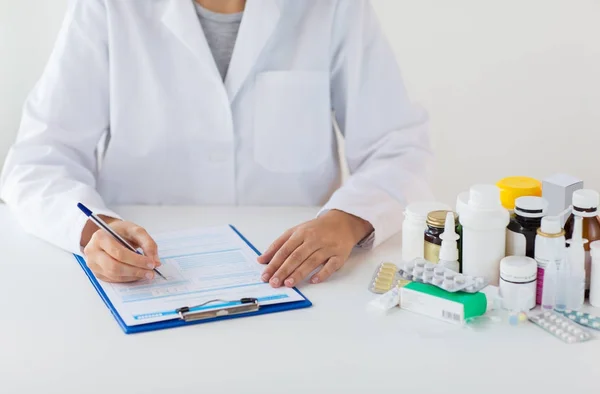 Arzt mit Medikamenten und Klemmbrett im Krankenhaus — Stockfoto