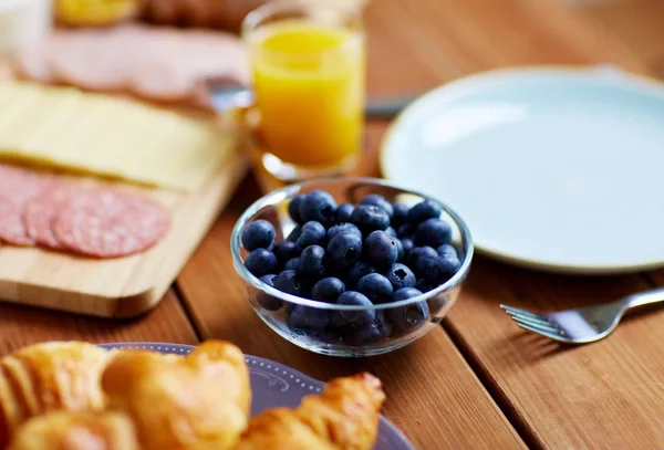 朝食は木製のテーブルの上のブルーベリーのボウル — ストック写真