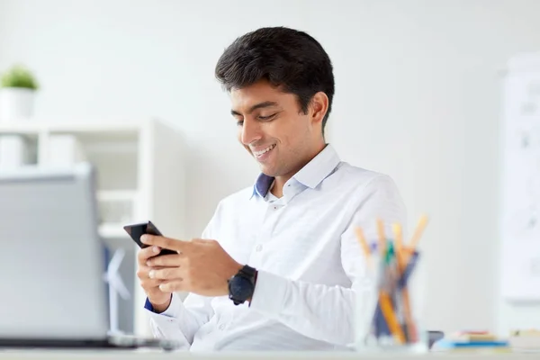 Uomo d'affari felice con smartphone in ufficio — Foto Stock