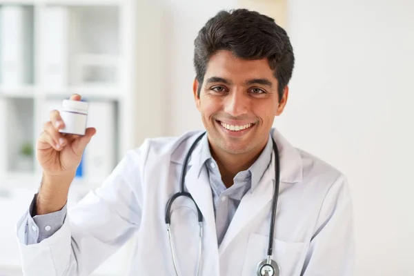 Счастливый доктор со стетоскопом и лекарствами — стоковое фото