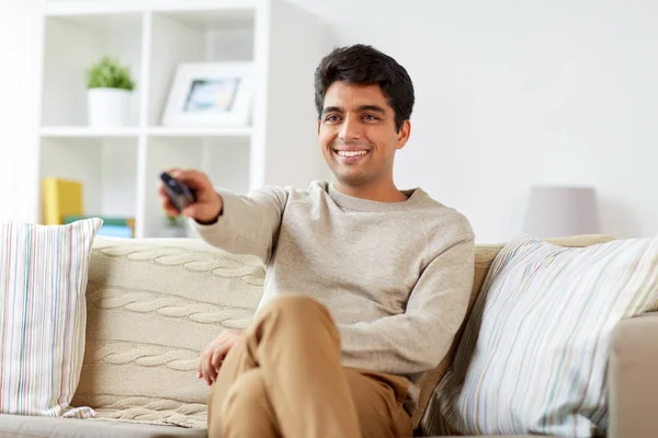 Hombre con mando a distancia viendo la televisión en casa —  Fotos de Stock