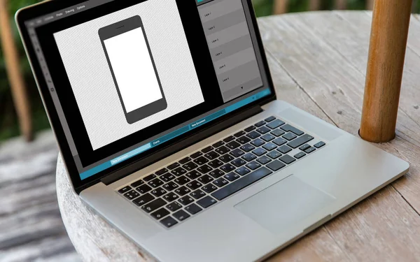 Laptop med smartphone bild i grafik redaktör — Stockfoto