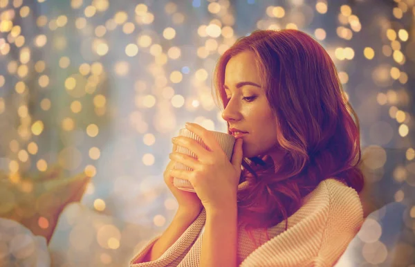 Gelukkige vrouw met kopje koffie in bed thuis — Stockfoto