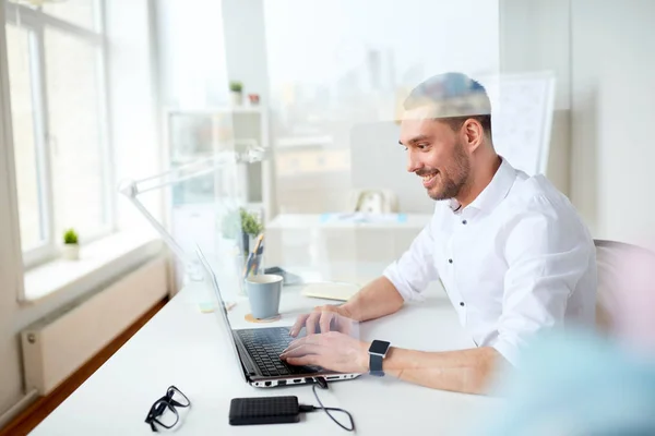 Glad affärsman att skriva på laptop på kontoret — Stockfoto