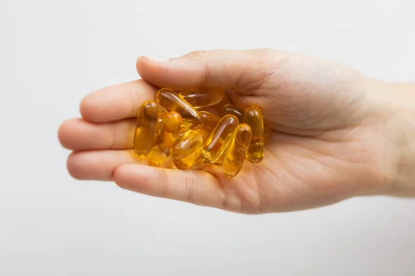 Mână care deține capsule de ulei de ficat de cod — Fotografie, imagine de stoc