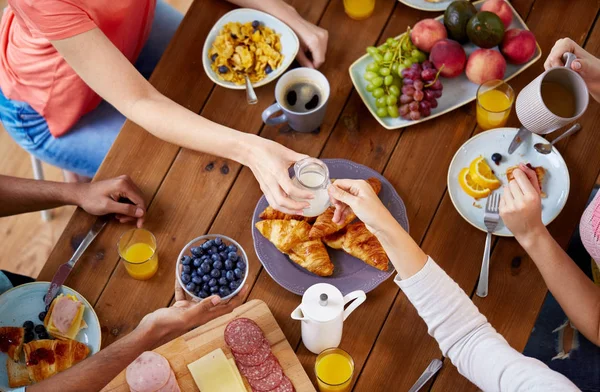 Pessoas tomando café da manhã à mesa com alimentos — Fotografia de Stock