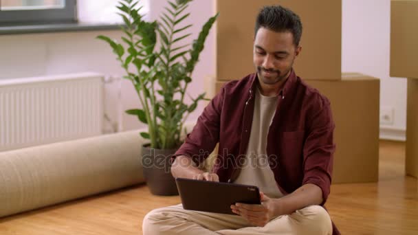 Uomo con tablet pc e scatole che si trasferiscono in una nuova casa — Video Stock