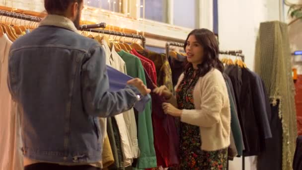 Pareja eligiendo ropa en tienda de ropa vintage — Vídeo de stock