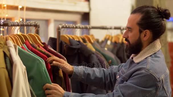Pareja eligiendo ropa en tienda de ropa vintage — Vídeos de Stock