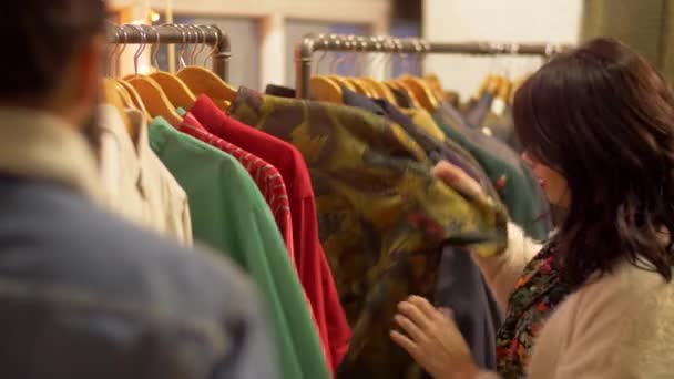 Paar kleding op de vintage kledingwinkel kiezen — Stockvideo