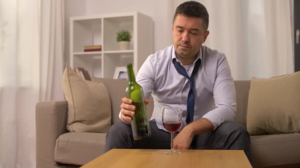 Alkoholiker schenkt zu Hause Rotwein ins Glas ein — Stockvideo