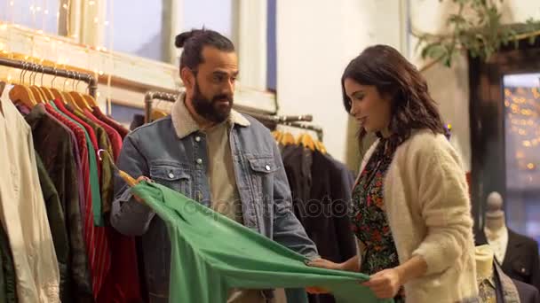 Пара выбирает одежду в магазине винтажной одежды — стоковое видео