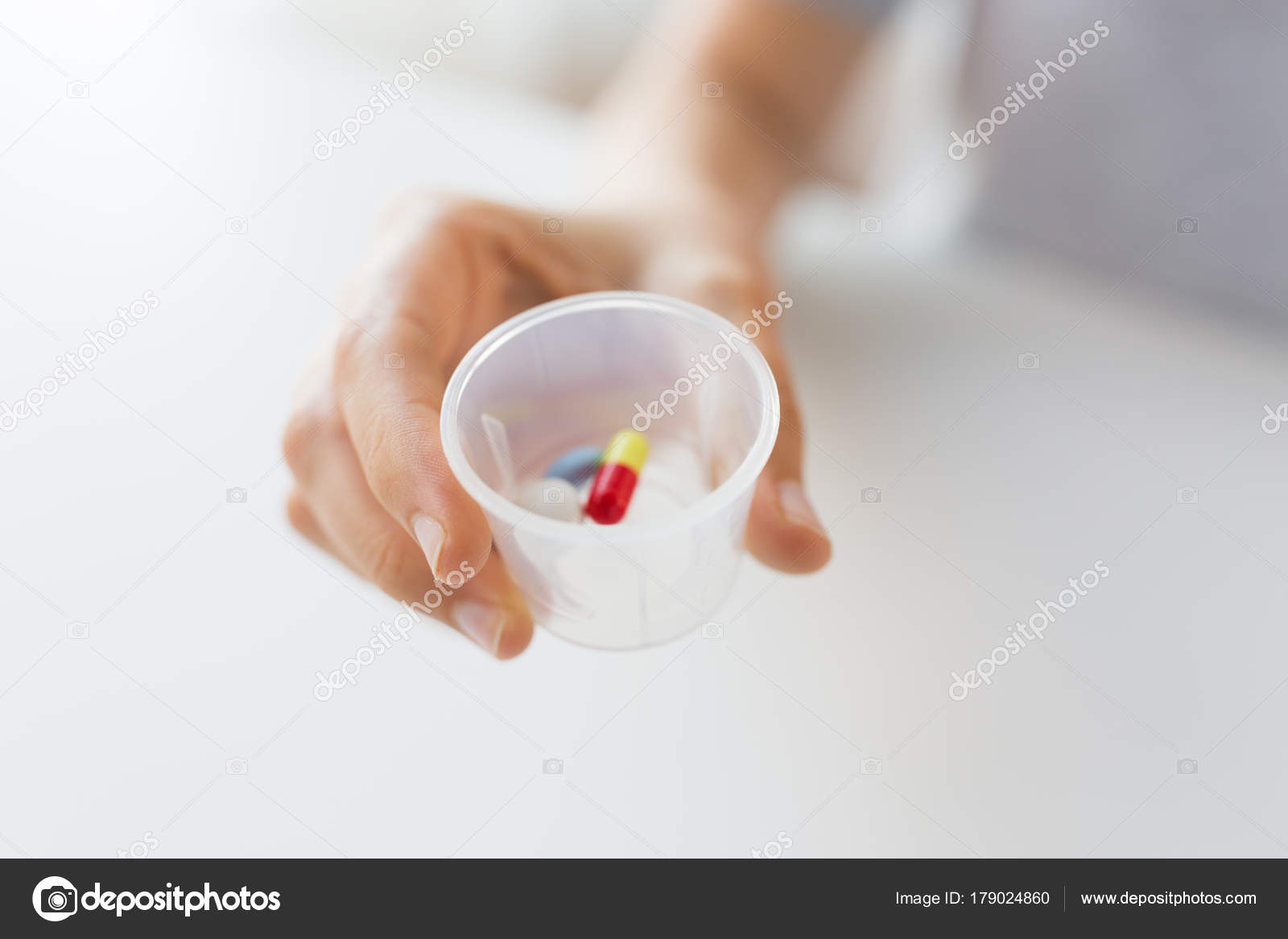 Close up of female hand with pills in medicine cup — Stock Photo ©  Syda_Productions #179024860