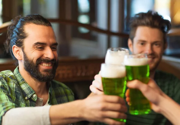 Männliche Freunde trinken grünes Bier in der Bar oder Kneipe — Stockfoto