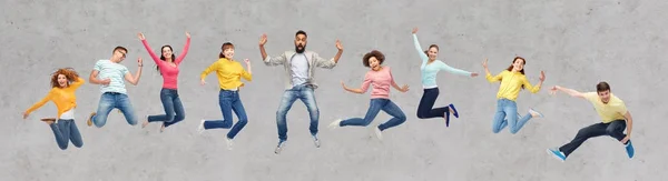 Personas felices o amigos saltando en el aire sobre gris — Foto de Stock