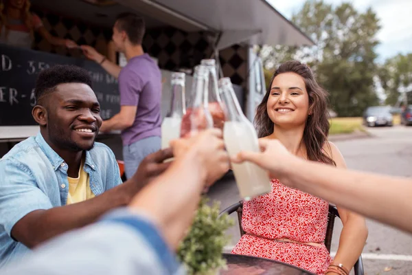 Przyjaciele brzęk butelek z napojami w food truck — Zdjęcie stockowe