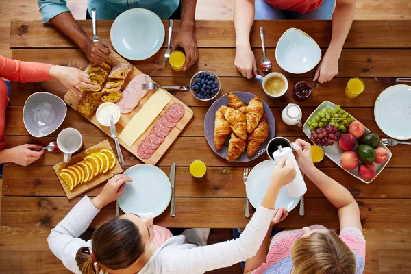 テーブルで朝食を持つ人々 のグループ — ストック写真