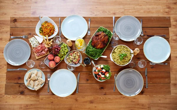 Různé potraviny na sloužil dřevěný stůl — Stock fotografie
