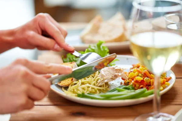 Hands of woman eating pasta with chicken meat — Stock Photo, Image