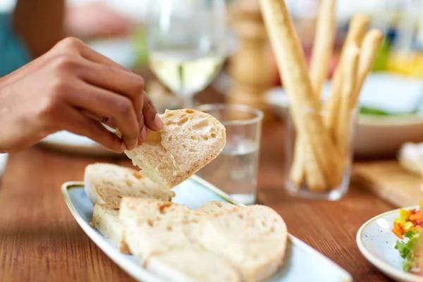 Рука берет кусок хлеба из тарелки — стоковое фото