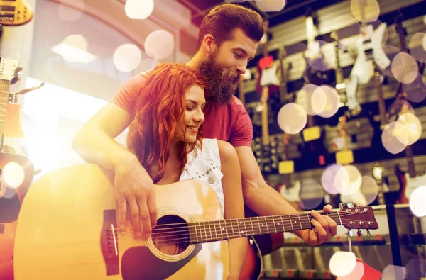 Par de músicos com guitarra na loja de música — Fotografia de Stock