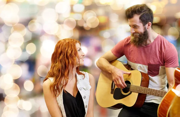 Pareja de músicos tocando la guitarra sobre luces — Foto de Stock