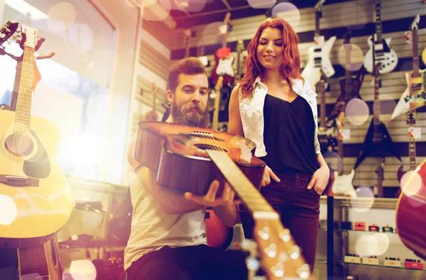 Pareja de músicos con guitarra en tienda de música —  Fotos de Stock