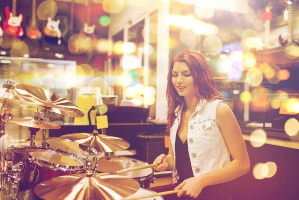Ženské hudebník hraje bicí souprava v obchodě s hudbou — Stock fotografie