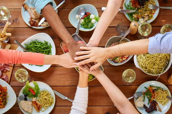 Menschen halten die Hände über dem Tisch mit Essen zusammen — Stockfoto