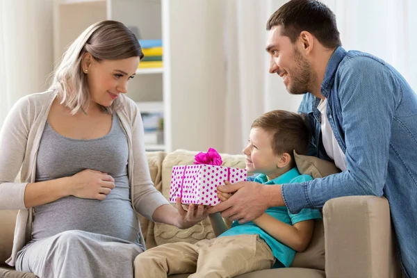 Famiglia che dà regalo alla madre incinta a casa — Foto Stock