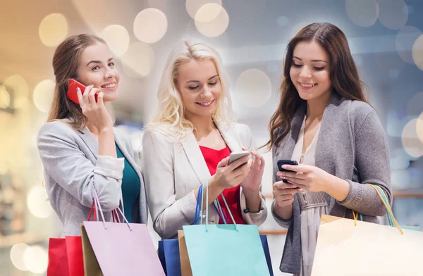 Šťastné ženy s smartphone a nákupní tašky — Stock fotografie