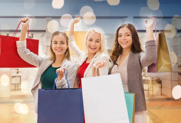 Felici giovani donne con shopping bags nel centro commerciale — Foto Stock