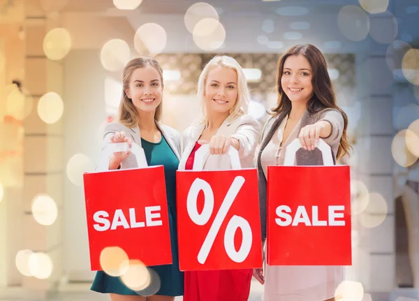 Mujeres jóvenes felices con bolsas de compras en el centro comercial — Foto de Stock