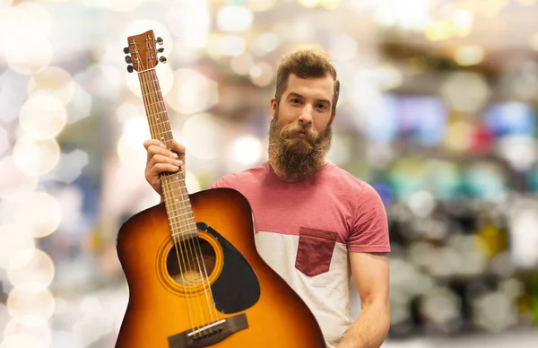 Männlicher Musiker mit Gitarre über hellem Hintergrund — Stockfoto