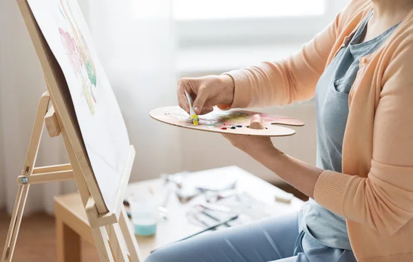 Artista aplicando tinta à paleta no estúdio de arte — Fotografia de Stock