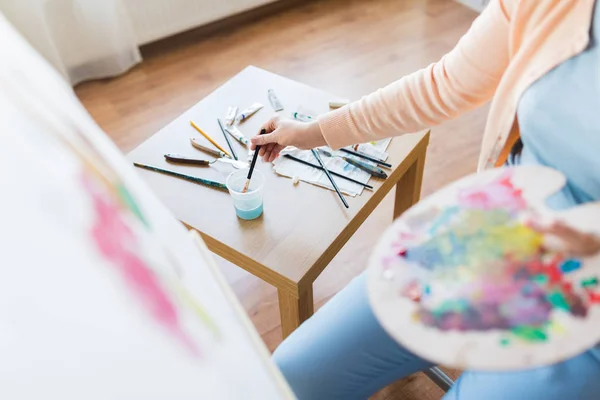 Artist washing paintbrush at art studio — Stock Photo, Image