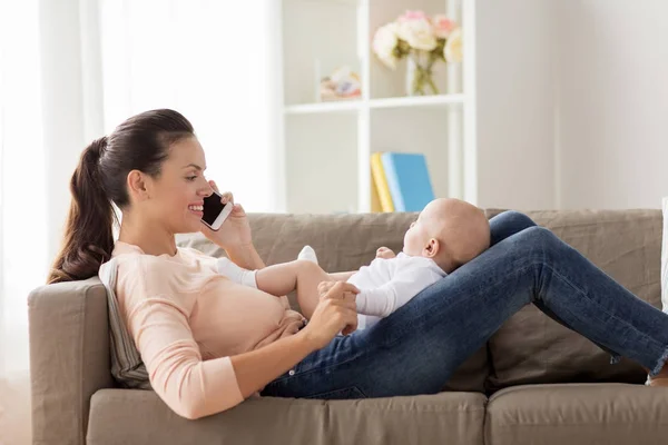 Mutter mit Baby telefoniert zu Hause mit Smartphone — Stockfoto