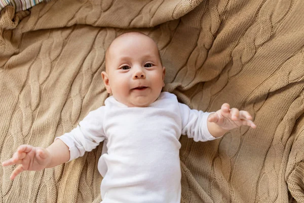 Süßer kleiner Junge liegt auf Strickdecke — Stockfoto