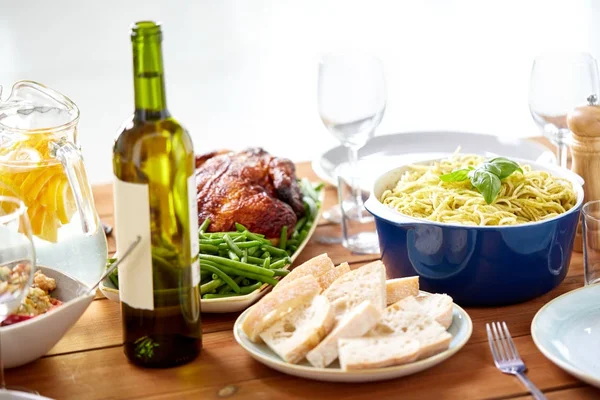 Garrafa de vinho e comida em mesa de madeira servida — Fotografia de Stock