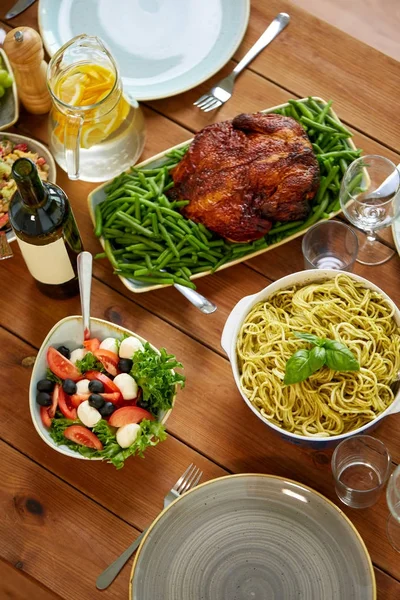 Těstoviny, zeleninový salát a pečené kuře na stole — Stock fotografie
