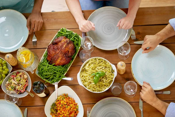 Groupe de personnes avec du poulet et des pâtes sur la table — Photo