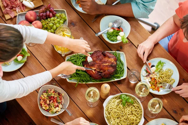 Skupina lidí jíst kuře k večeři — Stock fotografie