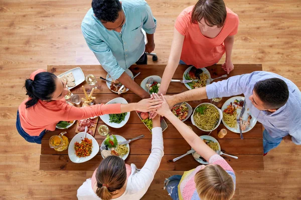 People holding hands together over table with food — Stock Photo, Image