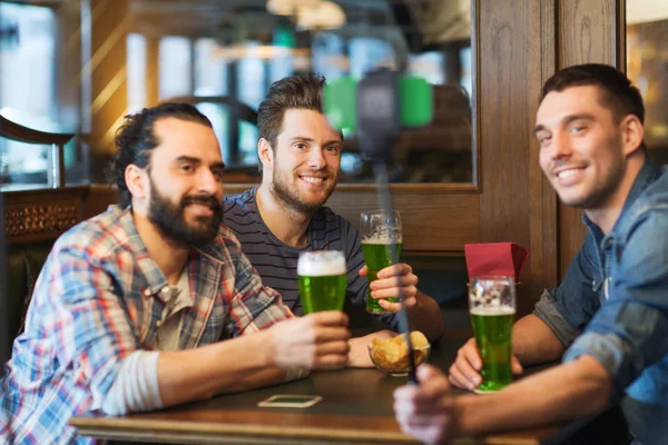 Друзья делают селфи с зеленым пивом в пабе — стоковое фото